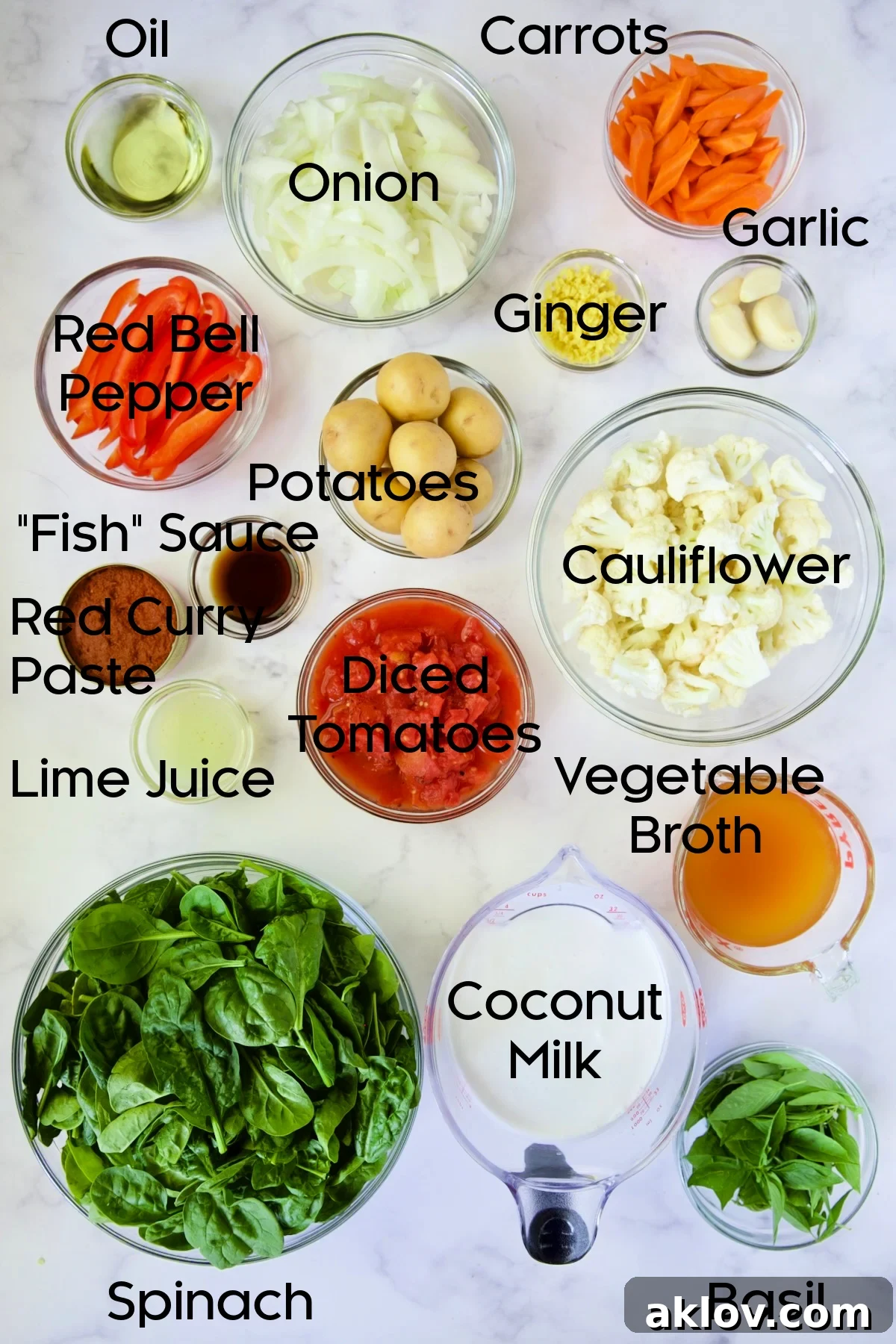 Various fresh ingredients for Vegan Thai Red Curry, including oils, spices, and chopped vegetables, neatly arranged in glass bowls.