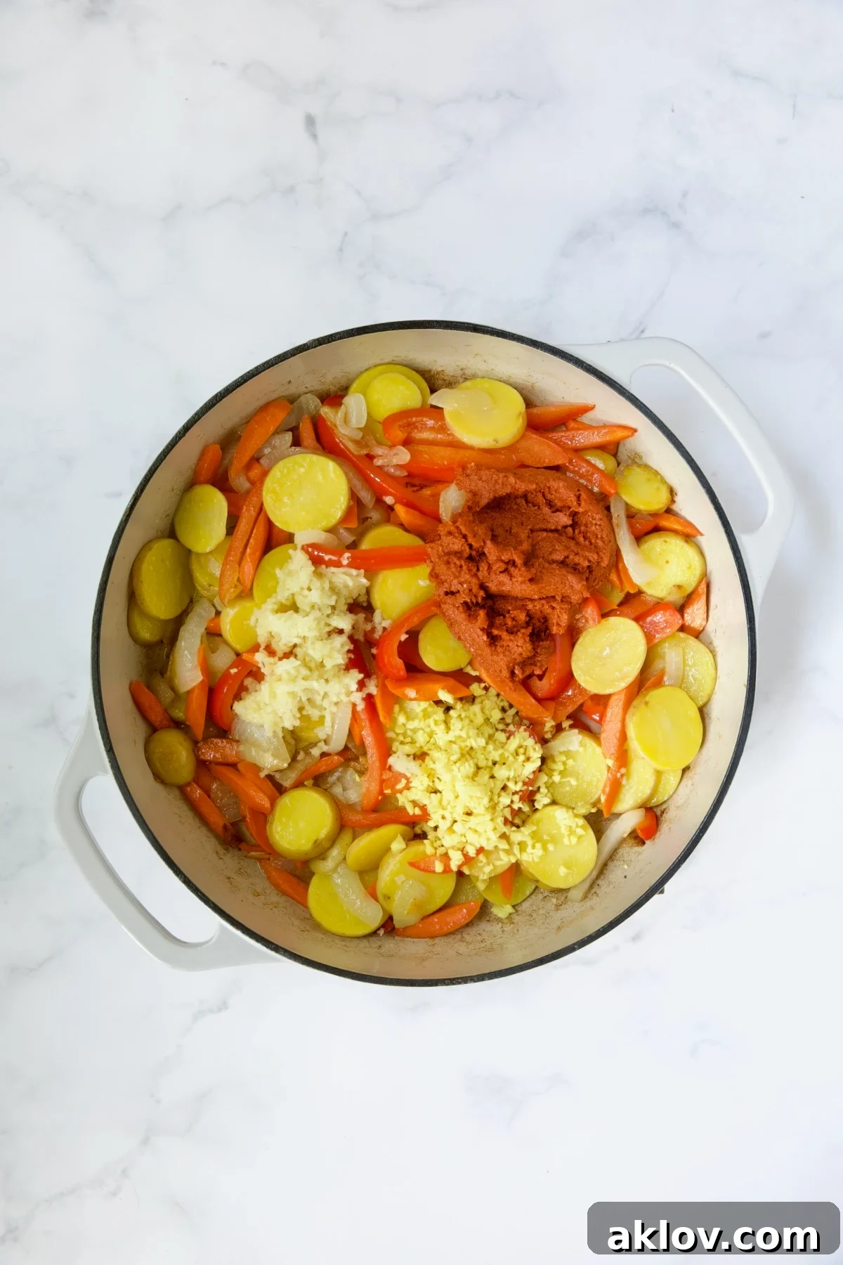 Process shot with potatoes, red bell pepper, and the addition of curry paste, ginger, and garlic, now thoroughly mixed.