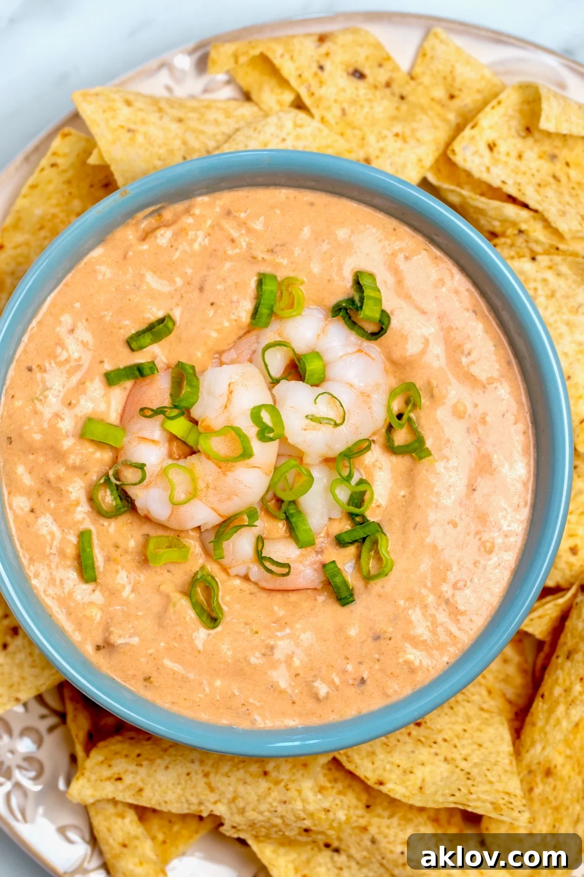 Creamy Shrimp Salsa Dip in bright blue bowl with tortilla chips.
