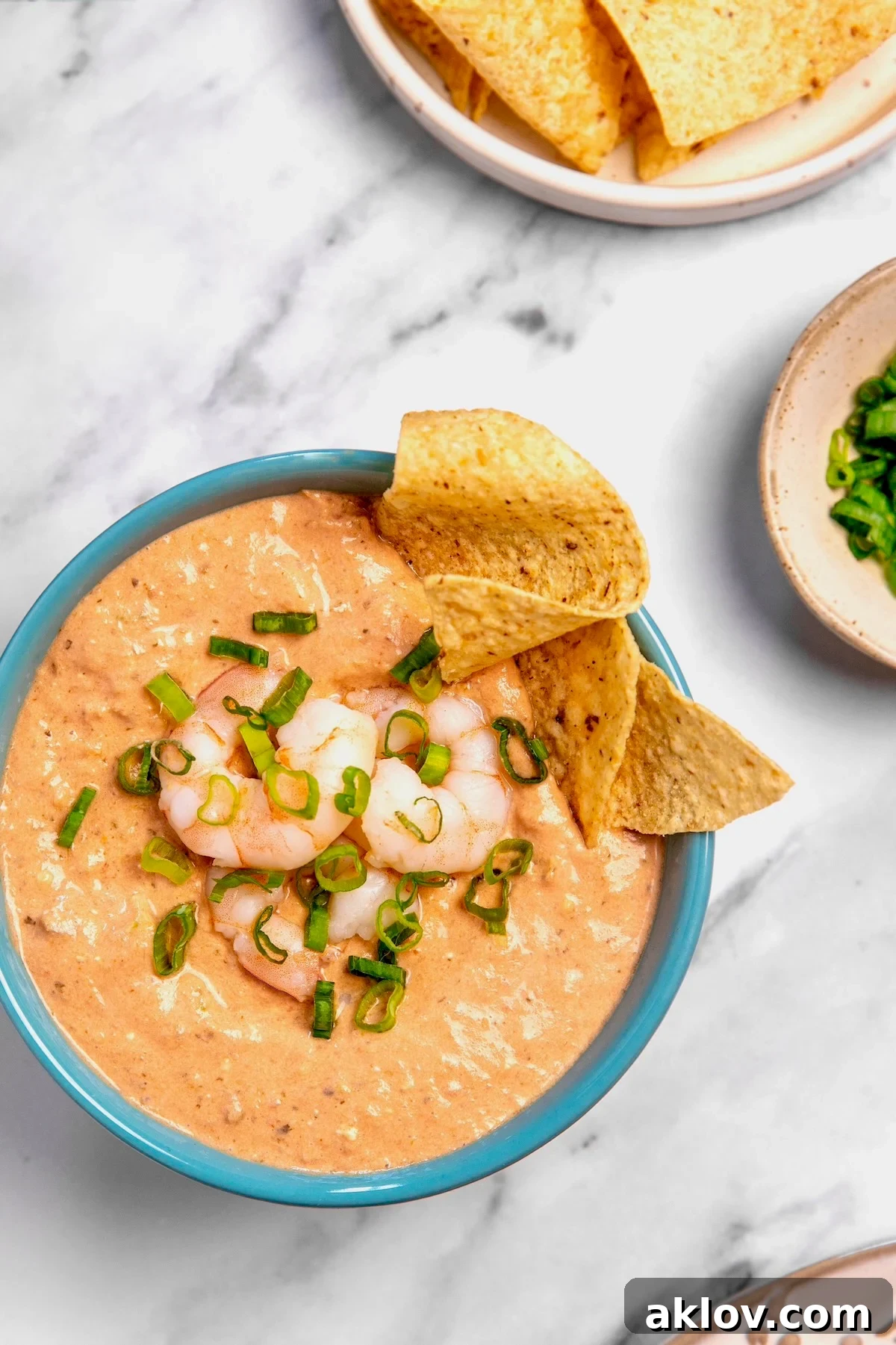 Creamy Shrimp Salsa Dip in bright blue bowl with tortilla chips.