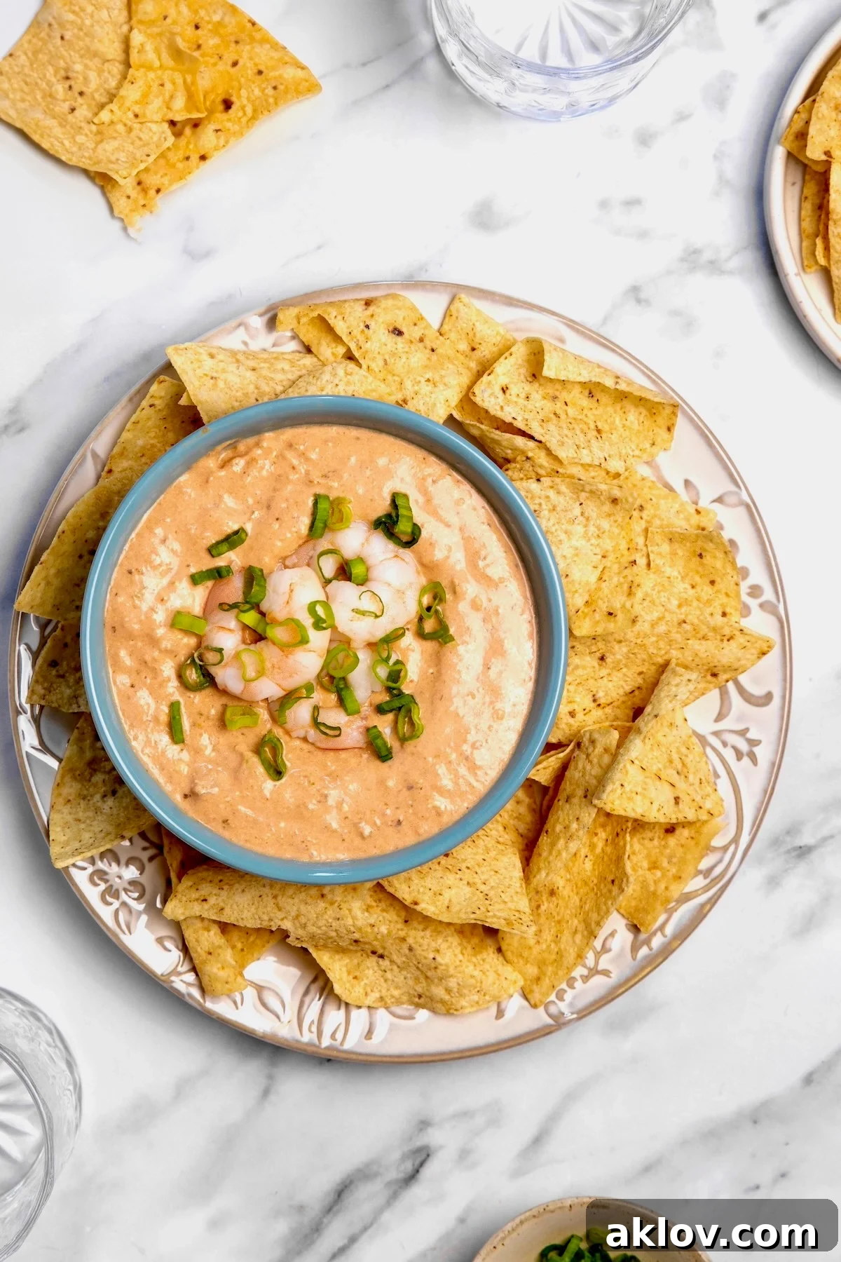 Creamy Shrimp Salsa Dip in bright blue bowl on platter with tortilla chips.