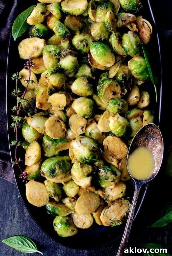 Roasted Brussels Sprouts with Thai Green Curry Butter on a sleek black platter.