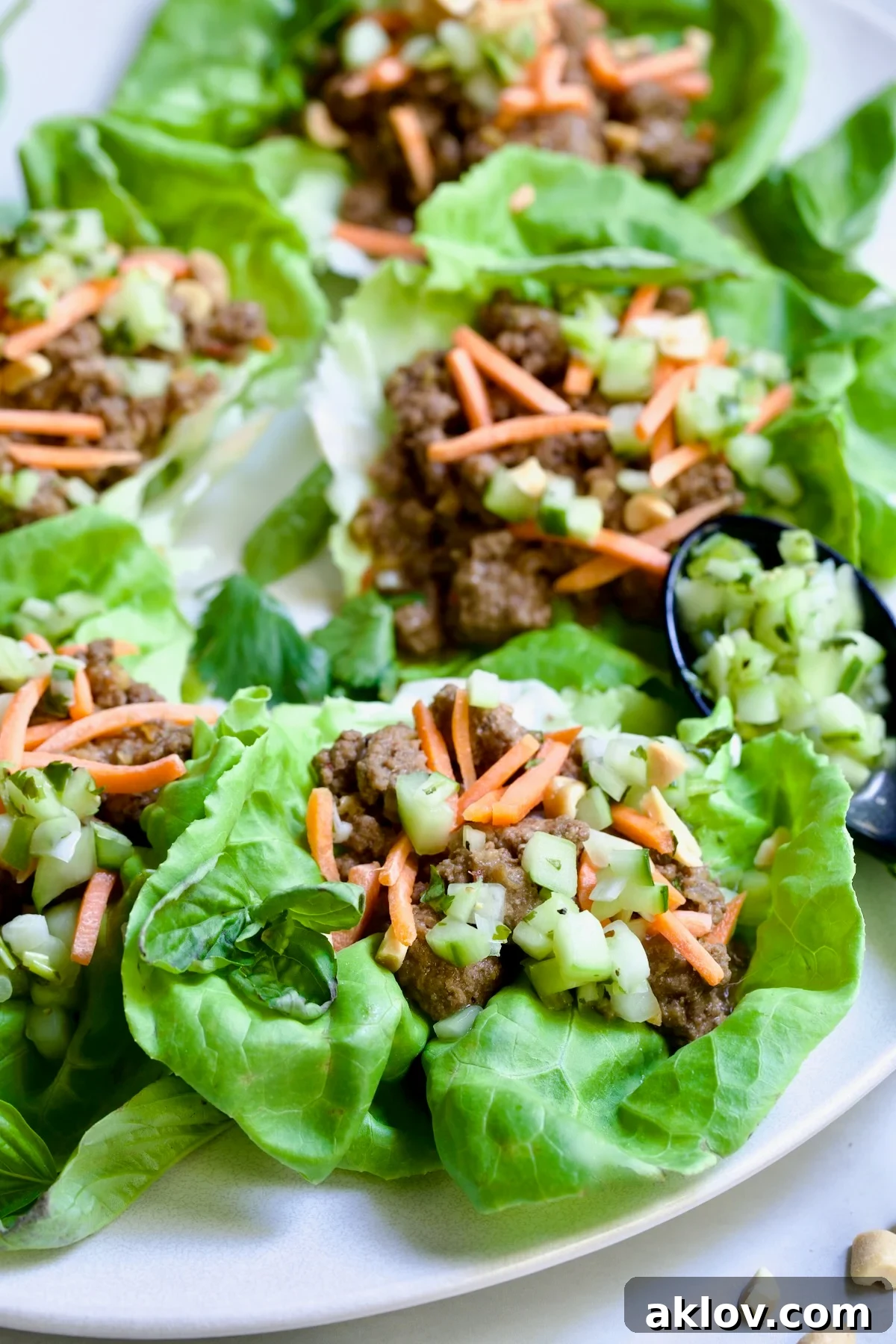 Six Vietnamese Beef Lettuce Wraps on white oval platter.