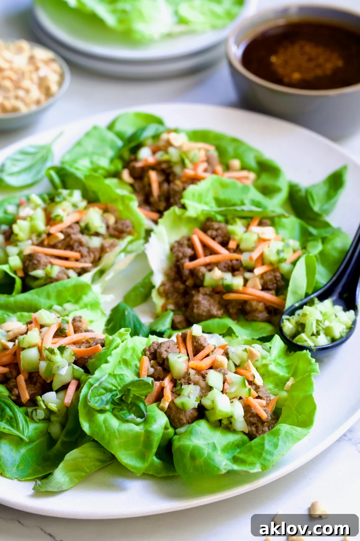 Six Vietnamese Beef Lettuce Wraps on white oval platter.
