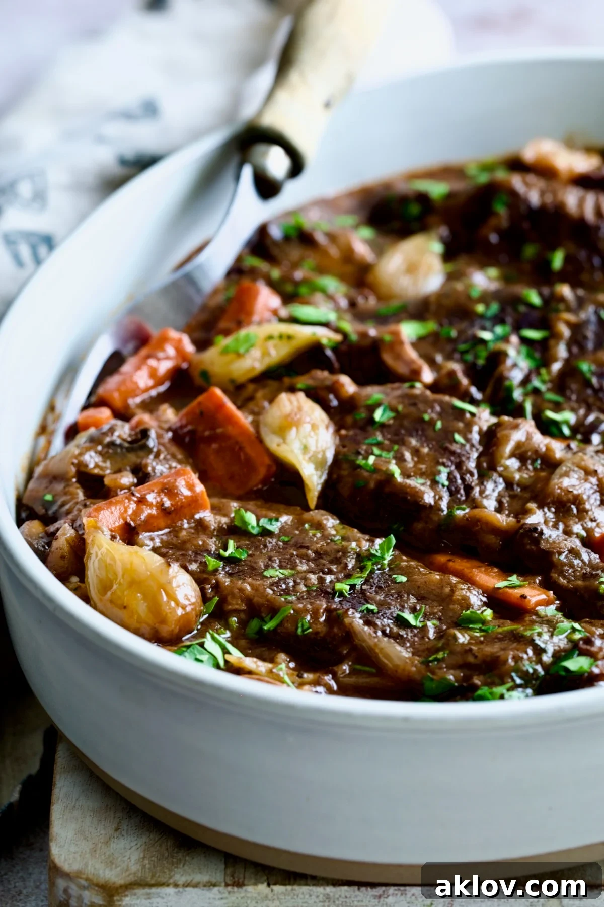 Tender Short Ribs Bourguignon served in an elegant white oval dish, ready to be enjoyed.
