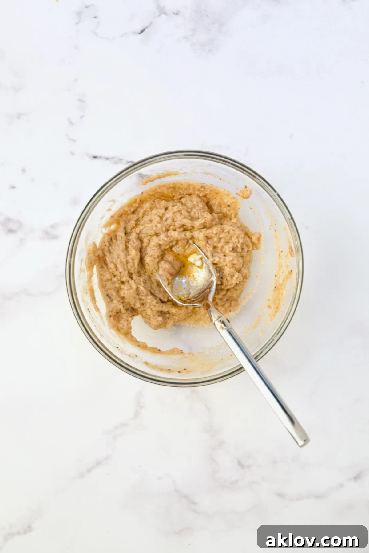 A small glass bowl holding flour, butter, and a portion of the hot braising liquid, mixed to form a thickening slurry.
