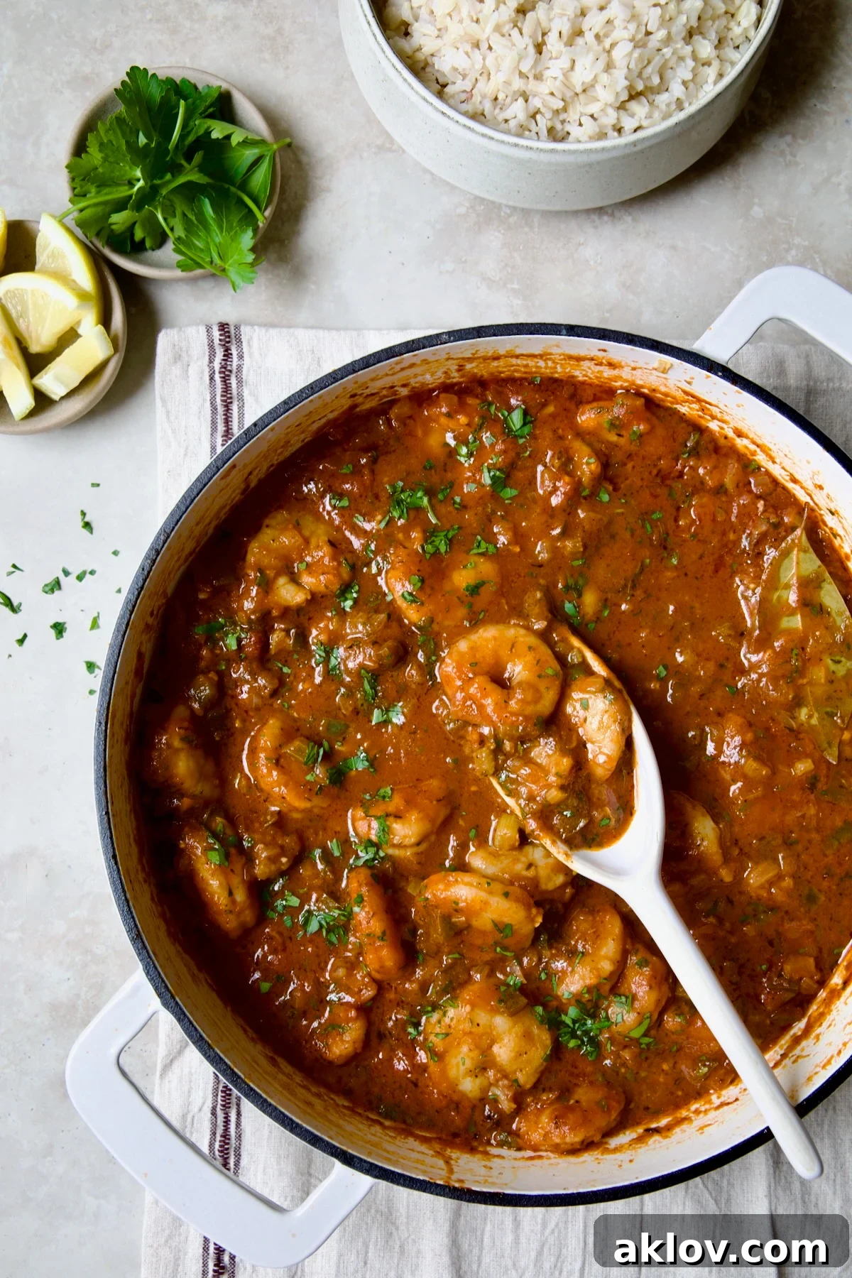 Finished Best Shrimp Creole in white enamel cast iron skillet with serving spoon.