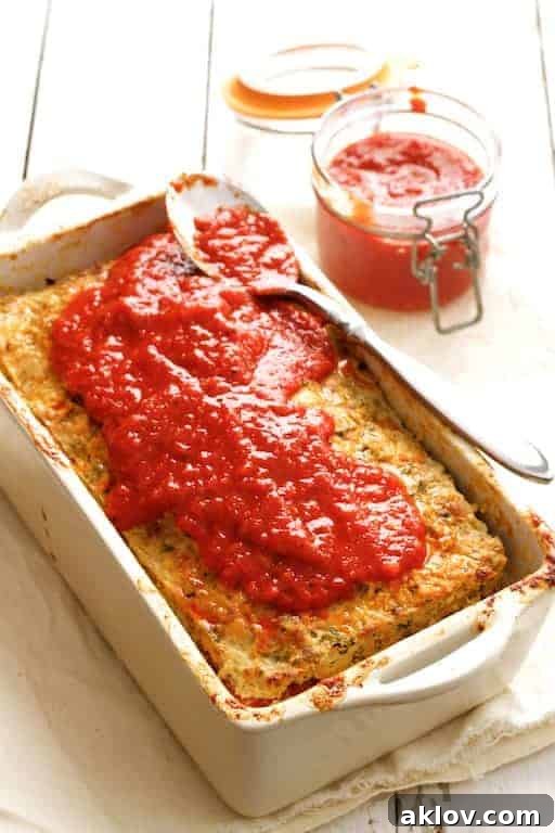 Turkey Meatloaf with Roasted Red Pepper Sauce in white loaf pan, ready for baking.
