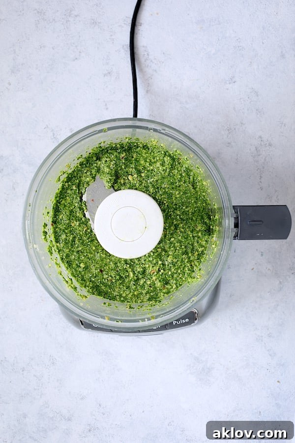 Photo of vibrant green Spinach Pesto Sauce in a food processor, ready to be blended.