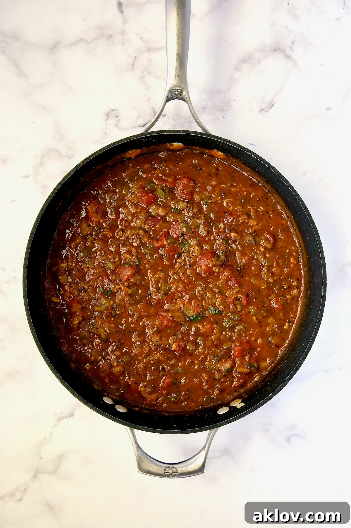 Rich tomato sauce simmering in a nonstick skillet for the stuffed peppers.