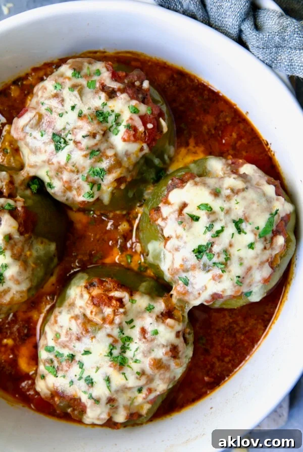 Three Italian Stuffed Peppers in deep white round baking dish.