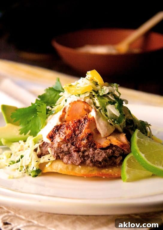 Fiesta Salmon Tostadas 2 Photo of Salmon and Black Bean Tostadas with Cilantro Lime Slaw and Chipotle Crema garnished with lime wedges.
