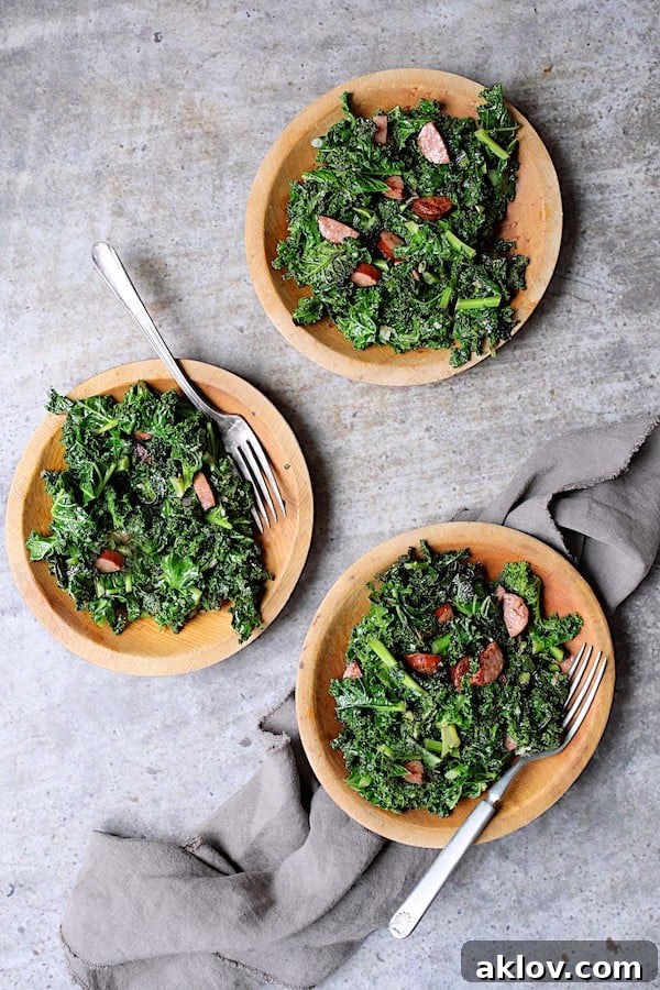 Spicy Sautéed Kale with Andouille Sausage - Overhead shot of three small wooden plates filled with this dish on gray background