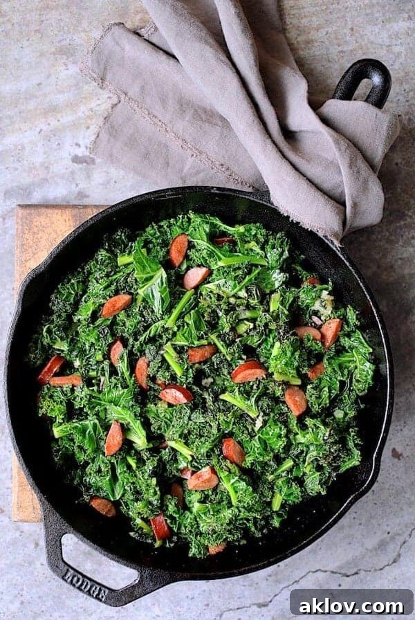 Spicy Sautéed Kale with Andouille Sausage in cast iron skillet.