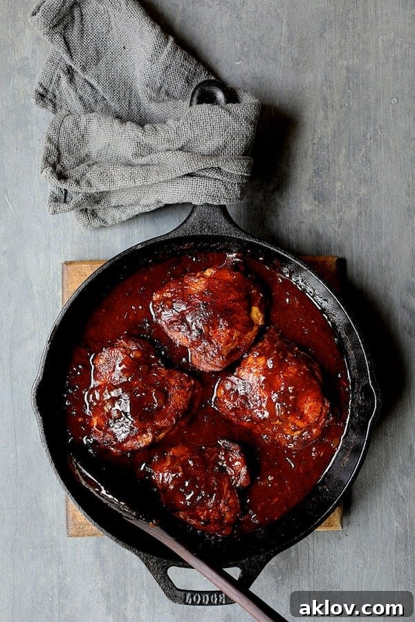 Photo of Korean Braised Chicken Thighs in a cast-iron skillet, un-garnished, showcasing the rich, thickened sauce.