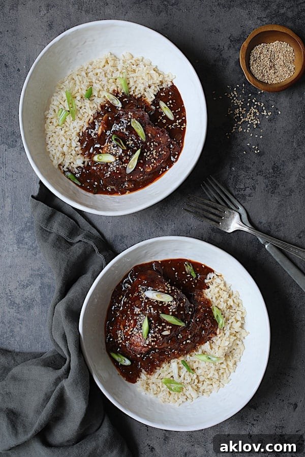 Photo of two servings of Korean Braised Chicken Thighs in white bowls, elegantly presented on a gray background.
