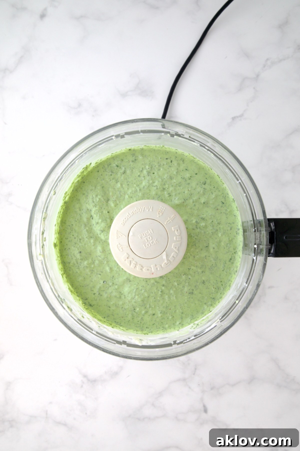 Yogurt and cream cheese in food processor with spinach added.