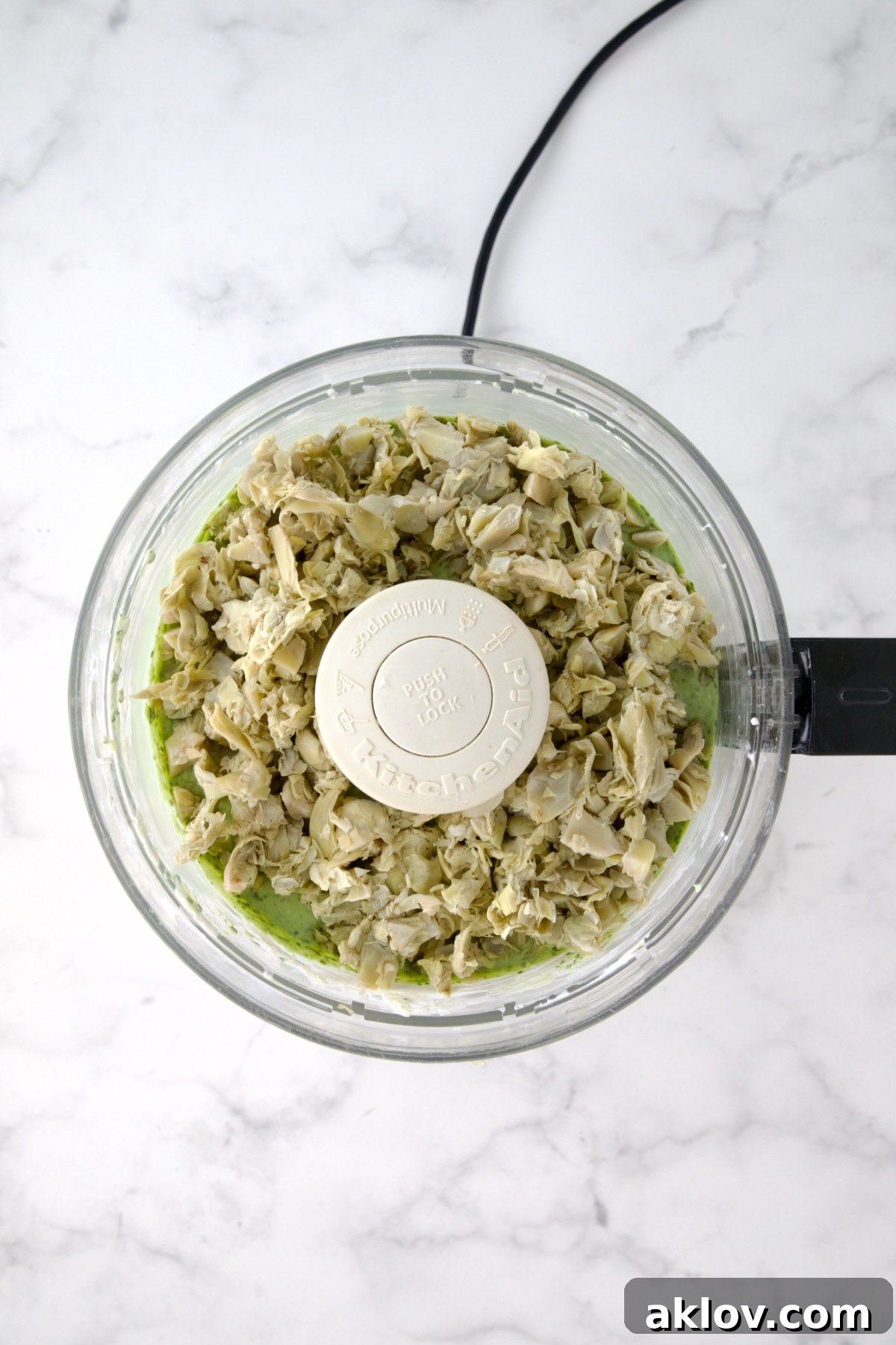 Chopped artichokes added to yogurt, cream cheese and spinach in food processor.