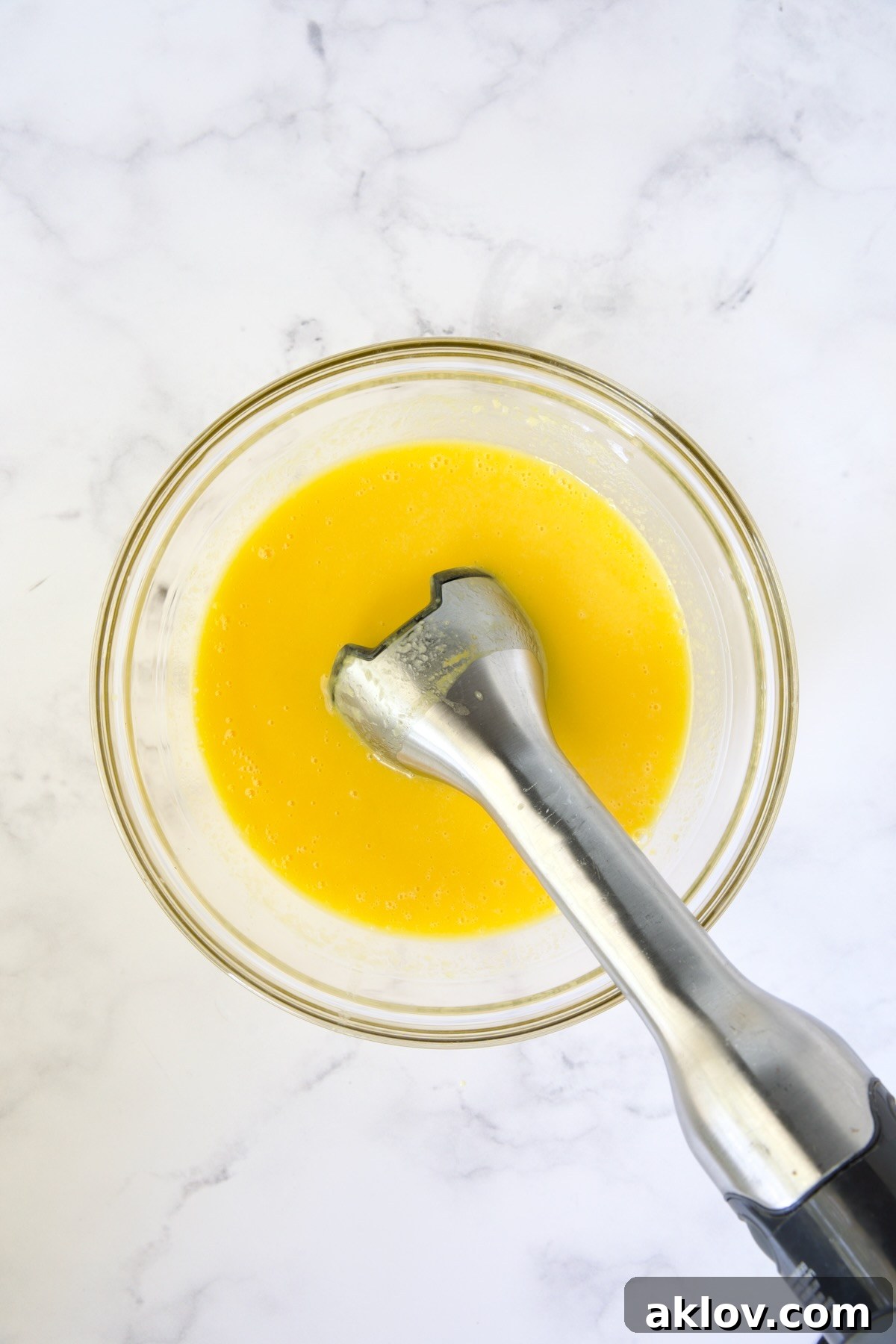 Immersion blender pureeing mango.