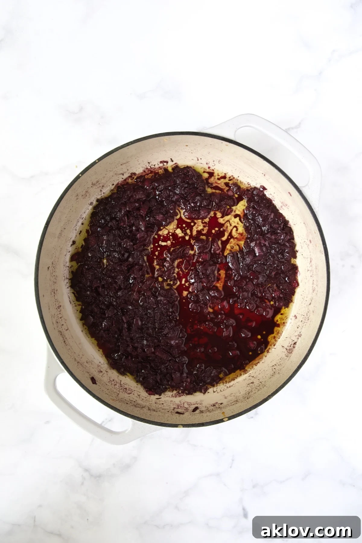 Red wine in white enamel cast iron skillet after being reduced.