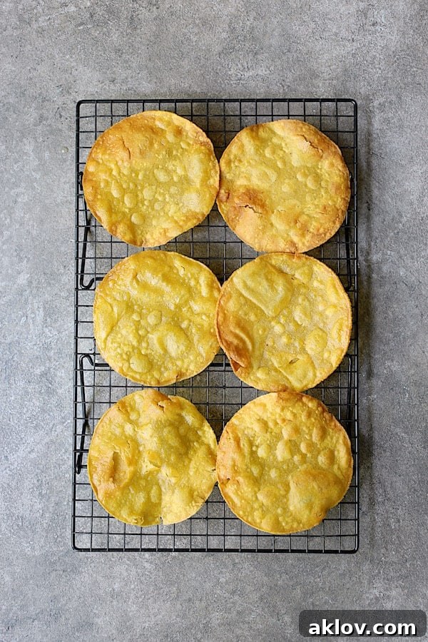 Photo of six fried tostada shells on cooling rack.