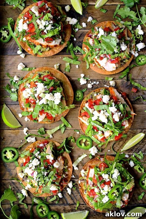 Photo of six Chicken Tostadas with Black Bean Guacamole and Salsa Fresca on wooden tray.