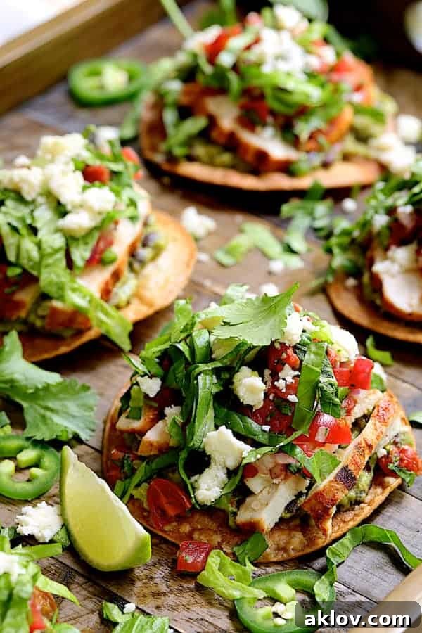 Close-up photo of Chicken Tostadas with Black Bean Guacamole and Salsa Fresca on wooden tray.