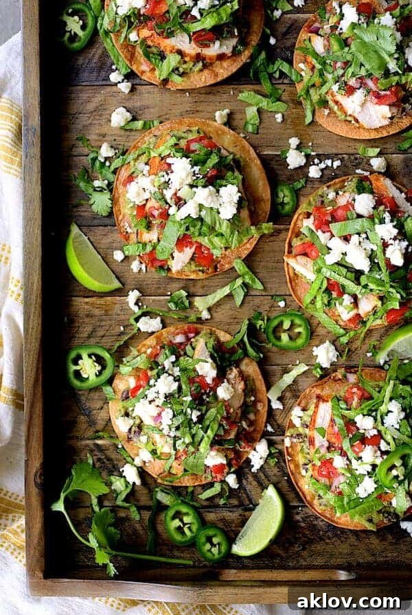 Six Chicken Tostadas with Black Bean Guacamole and Salsa Fresca on wood serving tray.