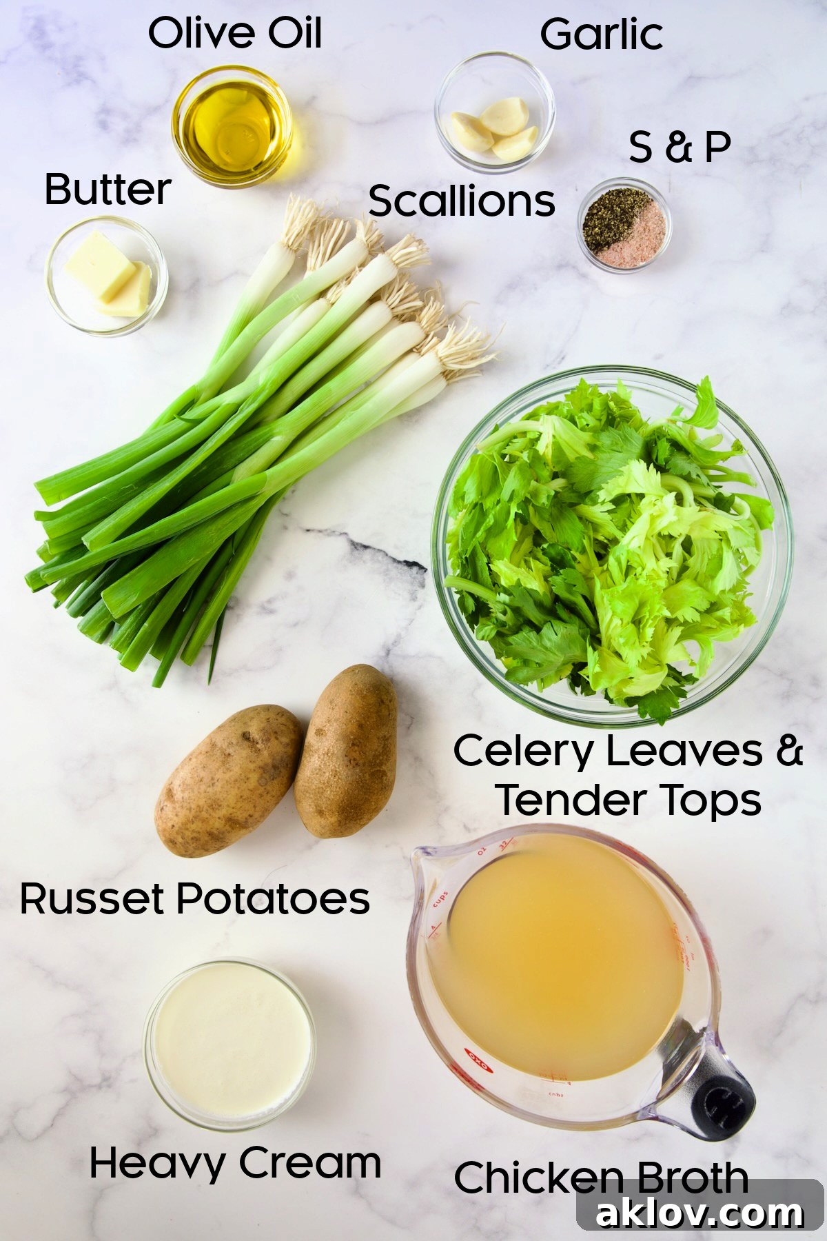 A collection of fresh ingredients for Creamy Celery Leaf Soup, including butter, olive oil, scallions, garlic, celery leaves, Russet potatoes, chicken broth, and heavy cream, neatly arranged in glass bowls.