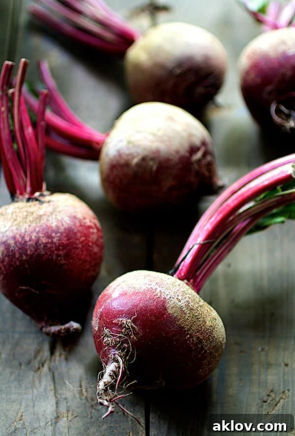 Fresh, raw beets with healthy green tops still attached, cleaned and ready for preparation.