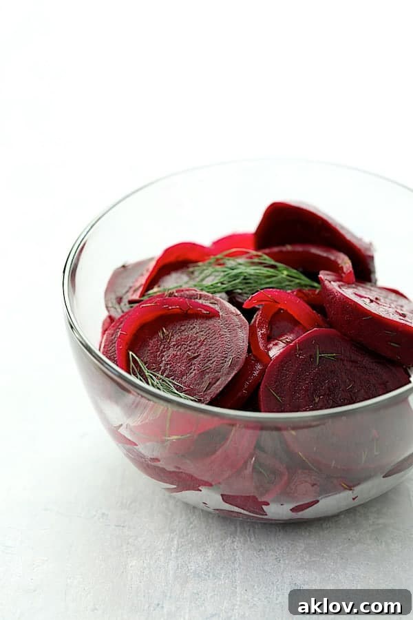 A glass bowl filled with vibrant quick pickled beets and fresh dill, ready to be served as a delightful side dish or appetizer.