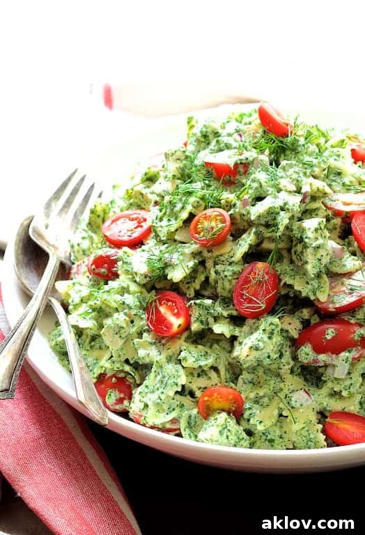 Vibrant Chicken Pasta Salad with Spinach Buttermilk Dressing served in a white bowl with elegant serving utensils, ready to be enjoyed.