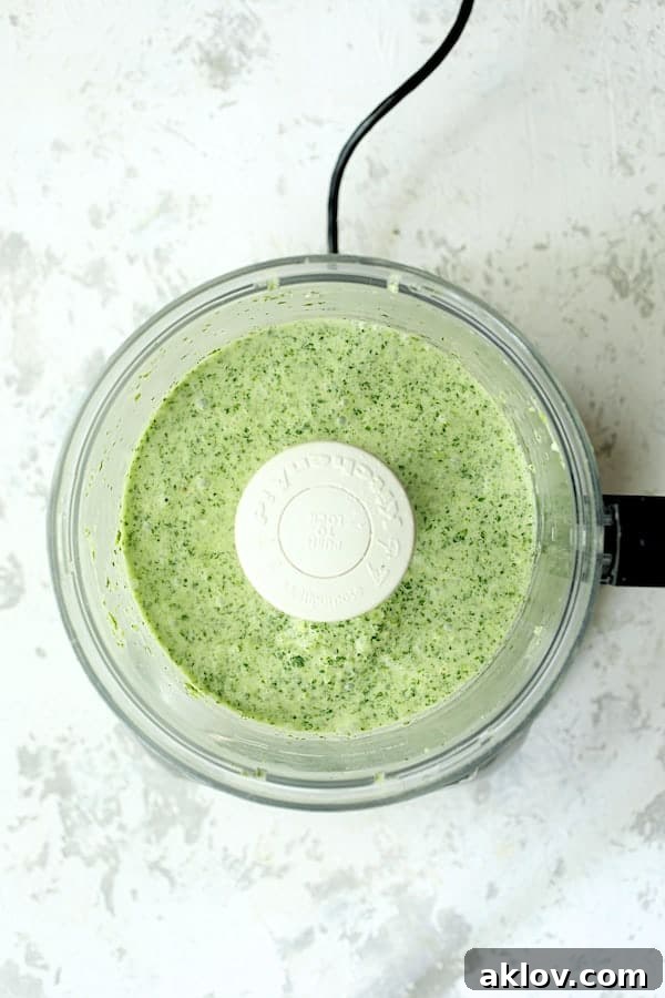 Overhead shot of fresh Cilantro Coconut Sauce being blended in a food processor