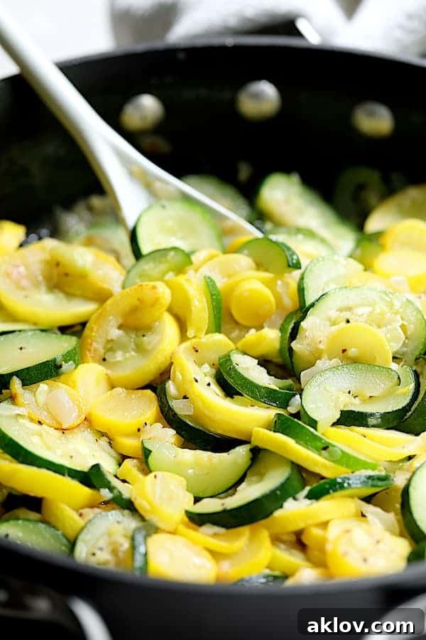 Zucchini and yellow squash being gently sautéed with onions in a large skillet, a vital step for a flavorful casserole base.