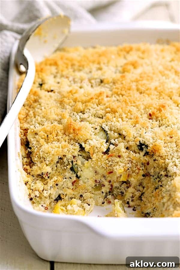 A close-up view of a serving of Zucchini, Yellow Squash and Quinoa Casserole, showcasing its creamy layers and textured topping.