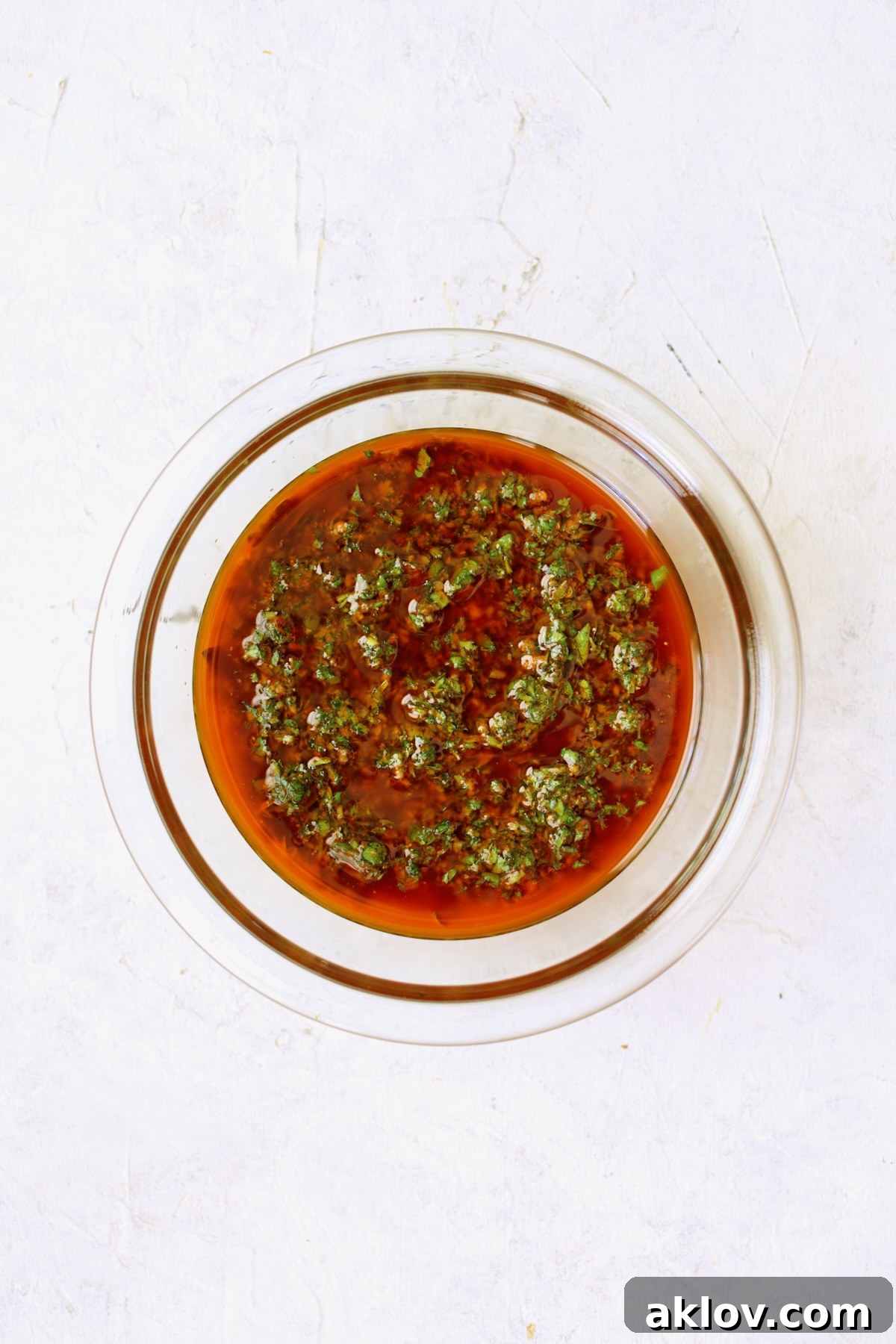 A glass bowl filled with vibrant green Charmoula marinade, showcasing its fresh herbs and spices.