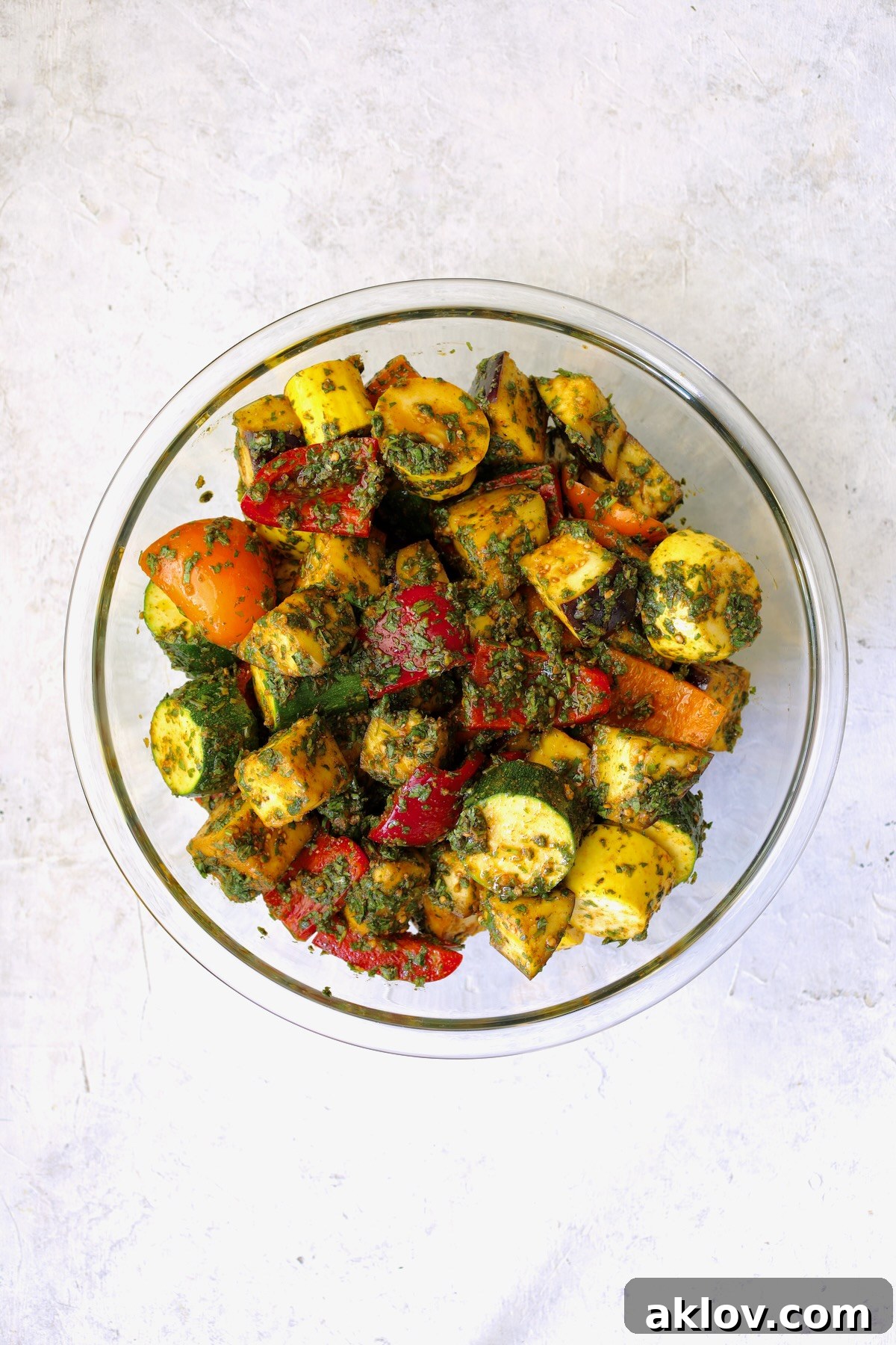 A glass bowl showcasing cubed vegetables, perfectly coated in the rich, vibrant Charmoula marinade.
