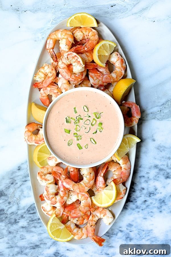 Photo of Shrimp Cocktail Louis on white oval platter garnished with lemon wedges.