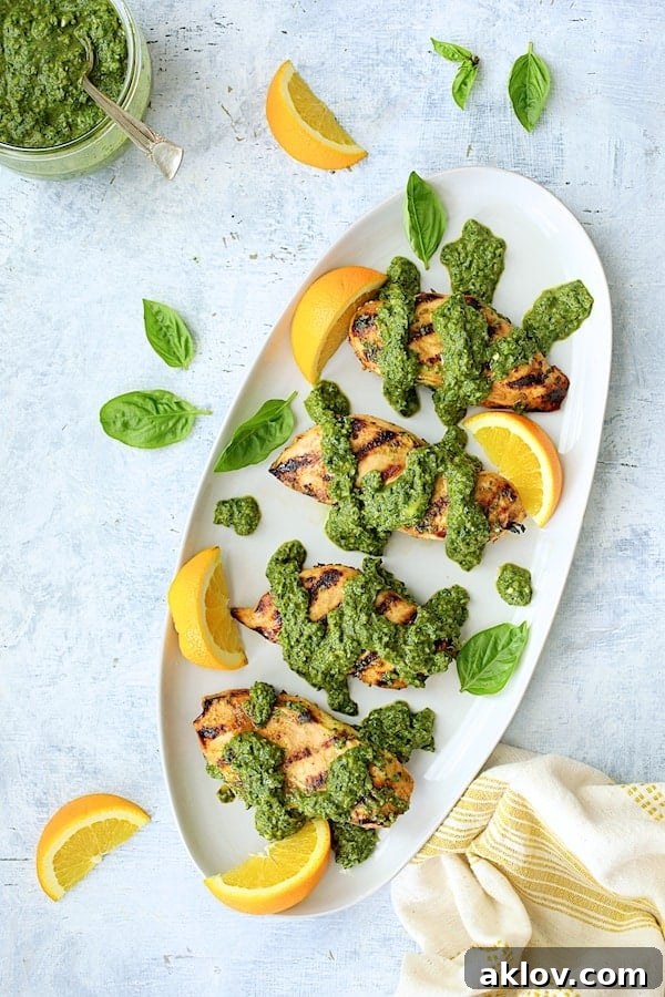 Photo of Grilled Citrus Chicken with Spicy Basil Chimichurri Sauce on white oval platter.