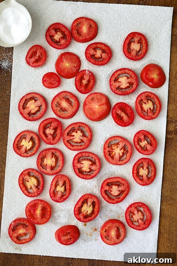 Photo of tomatoes draining on paper towels after being salted.