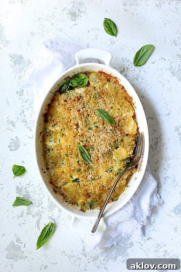 Photo of Yellow Squash and Tomato Gratin with Two Cheeses after being baked with serving fork.