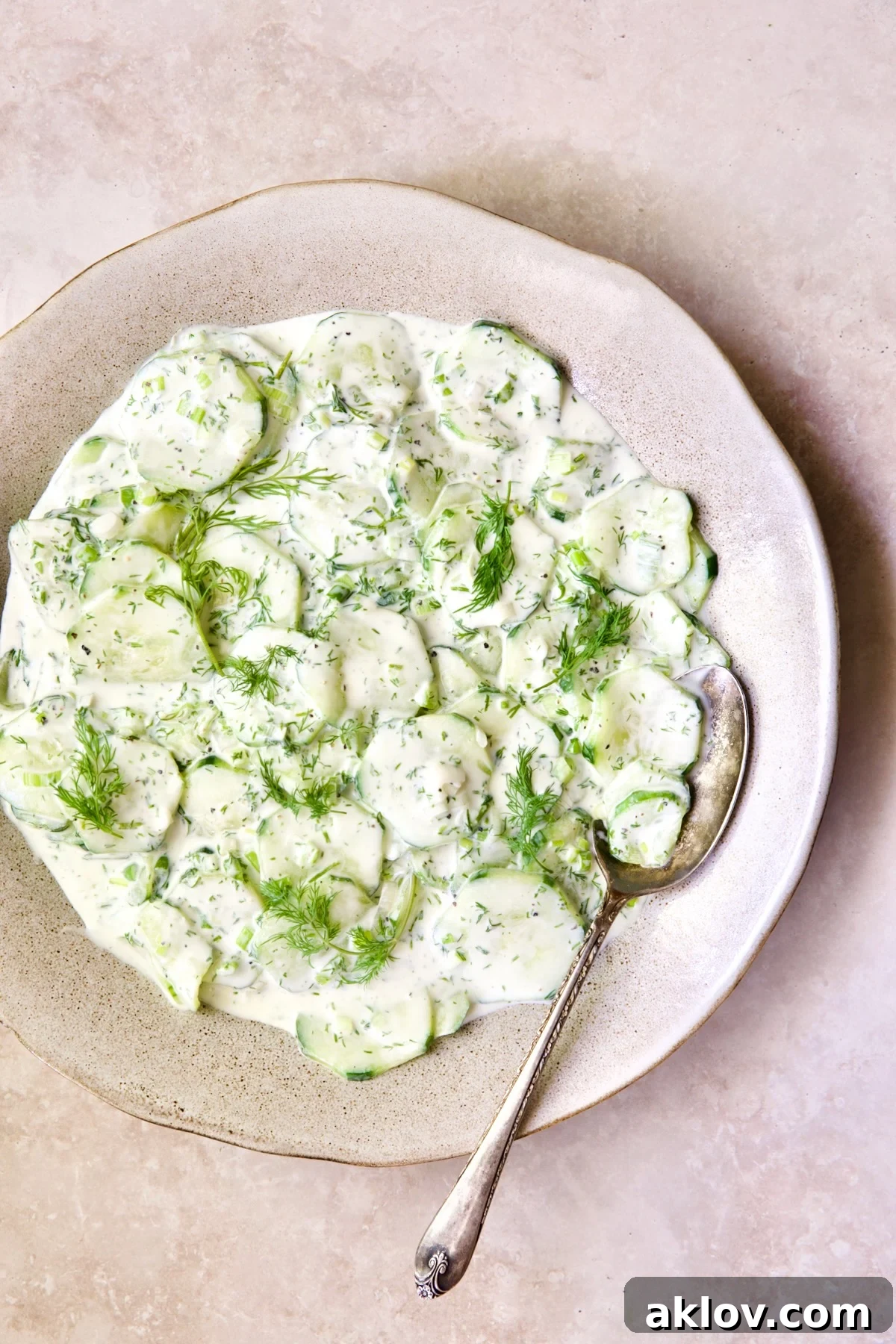 Yogurt Ranch Cucumber Salad in salad bowl with antique serving spoon.