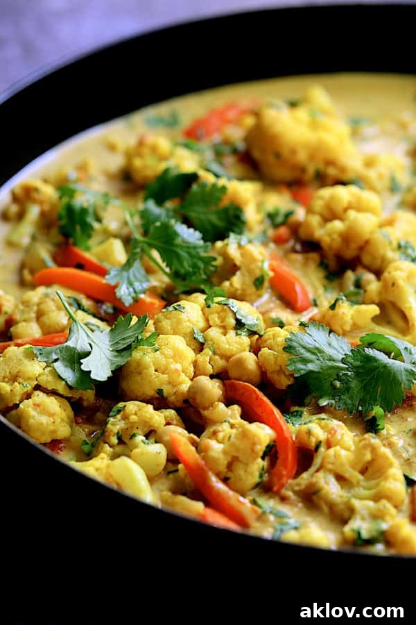 Golden Vegan Cauliflower Chickpea Curry 6 A close-up view of the rich, creamy Vegan Indian Cauliflower and Chickpea Curry, generously garnished with fresh cilantro, highlighting its inviting textures and colours.