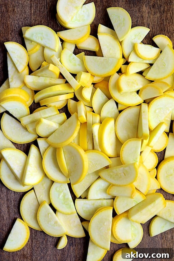 Photo of half-moon sliced yellow squash on cutting board.