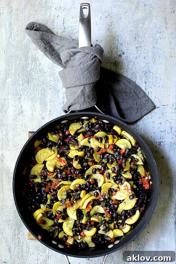 Photo of sauteed yellow squash with black beans added.