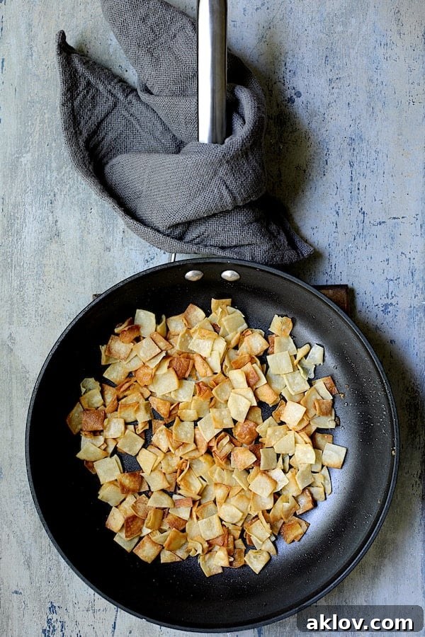 Photo of fried tortilla squares in skillet.