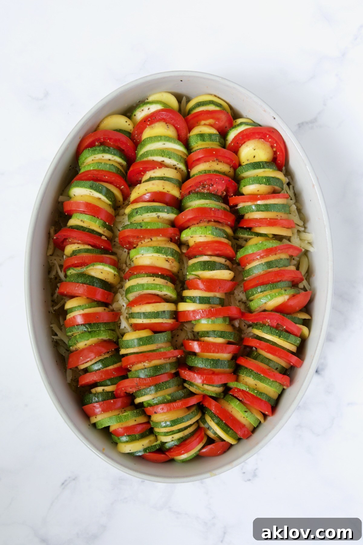 Tomatoes, zucchini and Yukon Gold potatoes in oval baking dish.