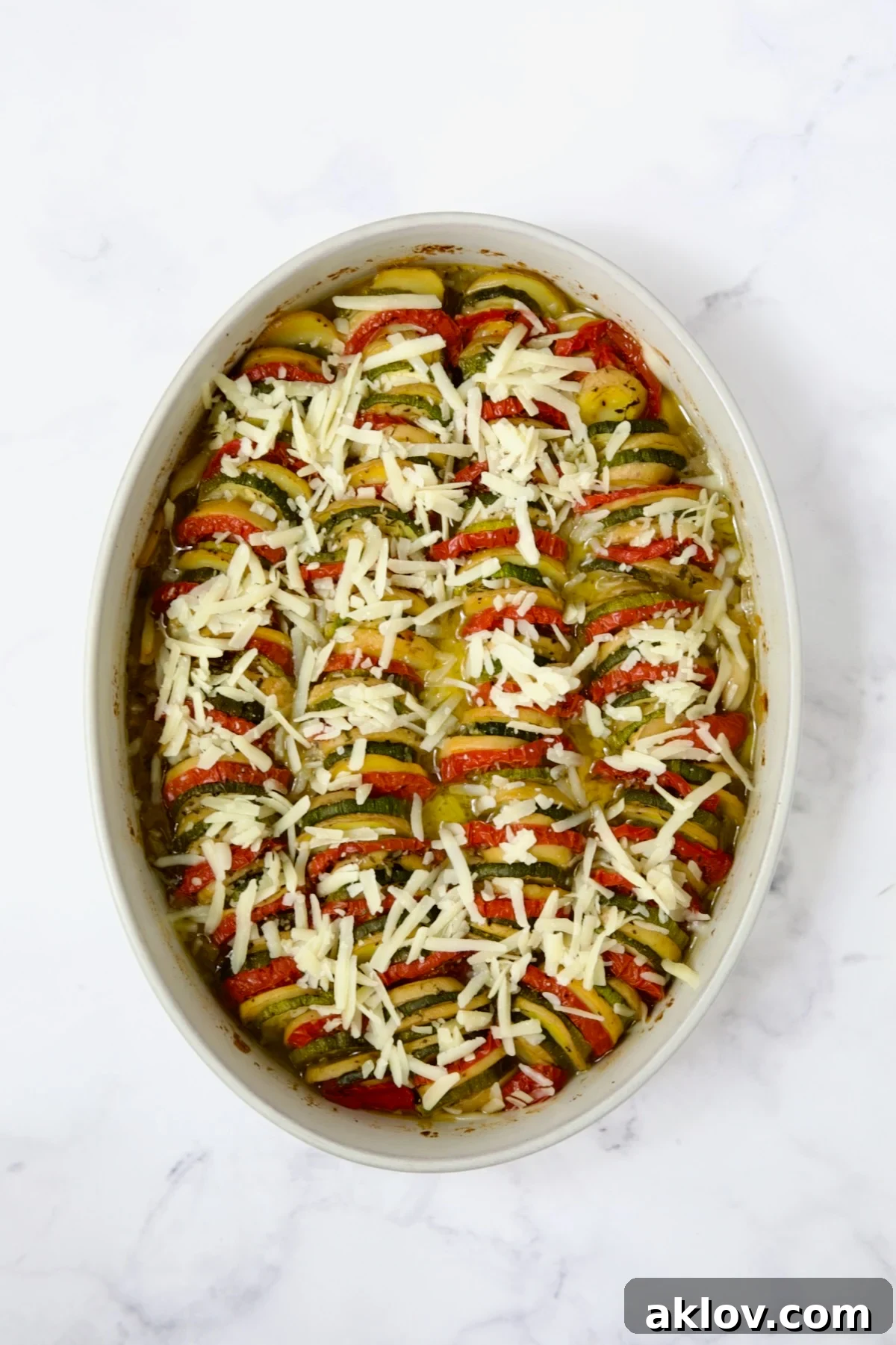 Melted cheese topping the cooked vegetables in the oval baking dish, golden brown and delicious.