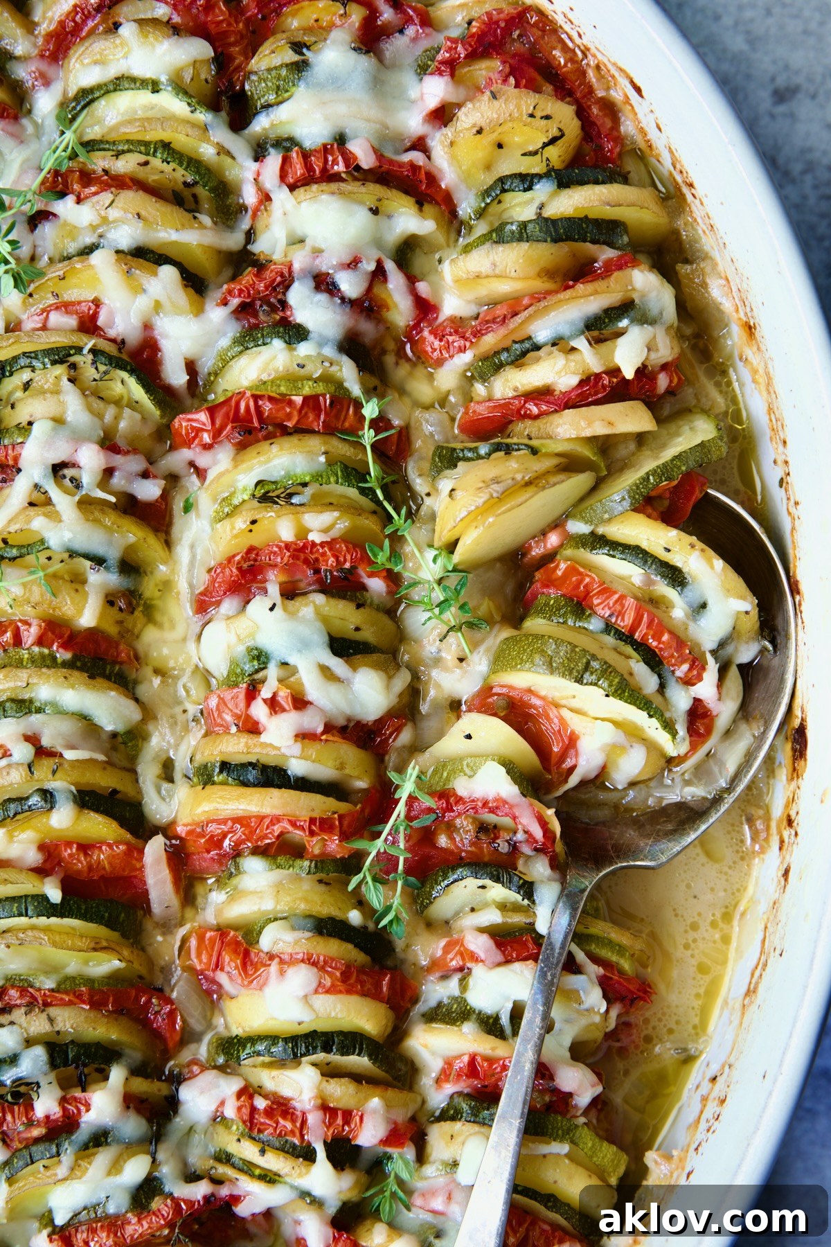 Vegetable Tian in oval baking dish with serving spoon.
