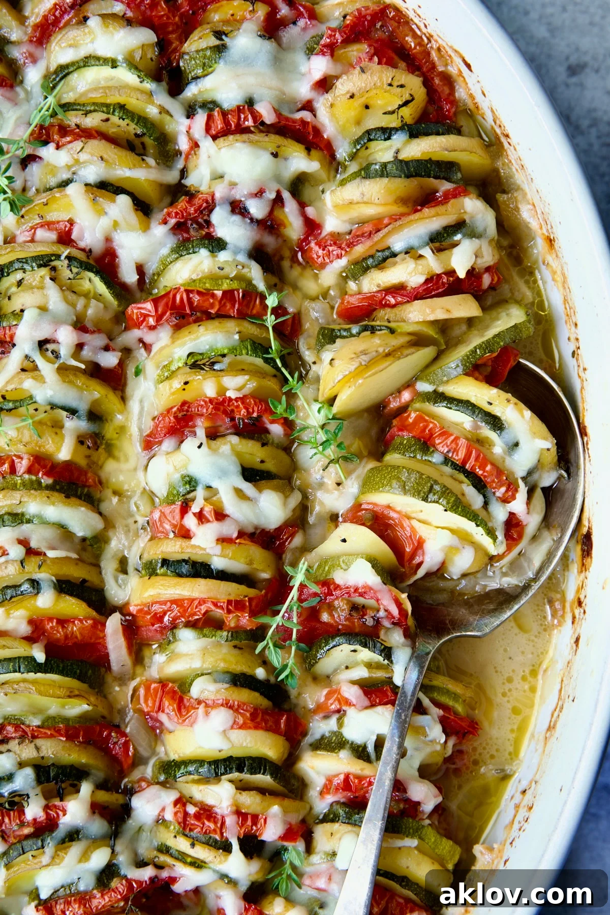 A serving of Vegetable Tian scooped from the baking dish onto a plate, showcasing its beautiful layers.